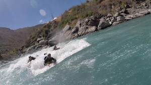 Rich (wearing green helmet) surfing the rapid