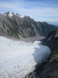 The glacier has receded back from the line of shrubs on the mountainside