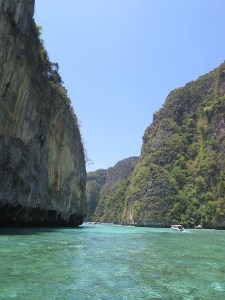 The cliffs of the islands loomed over the little boats passing through the water between them