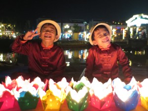 Vietnamese children selling floating lanterns for the river