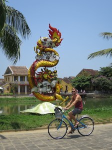 Rich cycling by riverside statues