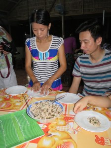 Being shown how to make spring rolls by Hung's daughter