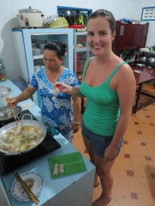 Sonia cooking the spring rolls with Mr Hung's wife in the kitchen